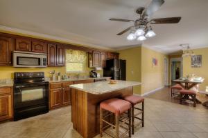 a kitchen with wooden cabinets and a island with bar stools at 5Bedrooms*4KING BEDS*OUTSTANDING LOCATION*HotTub* in Sevierville