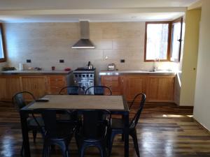 y cocina con mesa, sillas y fogones. en Chacra Arana cabaña de campo, en Villa Regina