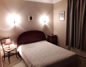 1 dormitorio con 1 cama y 2 luces en la pared en Maison provençale chaleureuse avec piscine en Mouriès