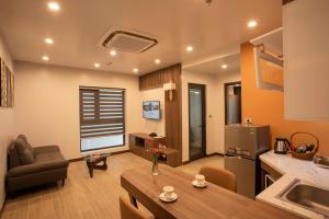 una cucina e un soggiorno con divano e tavolo di ZEN RIVERSIDE HOTEL & RESIDENCES a Hai Phong