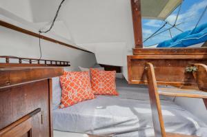 a small bed in a boat with orange pillows at Blue Oasis in Downtown St Augustine in Saint Augustine