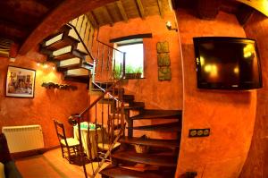 un escalier en colimaçon dans une pièce avec une télévision et un téléviseur dans l'établissement Senda Del Alba, à Fresneda de Cuéllar