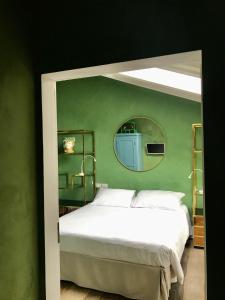 een slaapkamer met een wit bed en een spiegel bij B&B Cà Bianca dell'Abbadessa in San Lazzaro di Savena