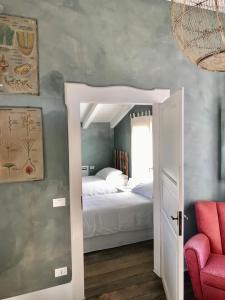 um quarto com uma cama, um espelho e uma cadeira em B&B Cà Bianca dell'Abbadessa em San Lazzaro di Savena