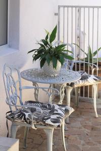 un tavolo e sedie con una pianta in vaso di Olive tree private rooms in Stellenbosch- No Load Shedding a Stellenbosch