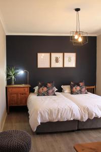 una camera con un grande letto e una parete nera di Olive tree private rooms in Stellenbosch- No Load Shedding a Stellenbosch