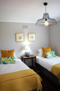 una camera con due letti e una lampada su un tavolo di Olive tree private rooms in Stellenbosch- No Load Shedding a Stellenbosch