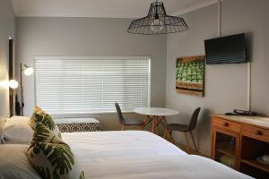una camera con letto e tavolo con sedie di Olive tree private rooms in Stellenbosch- No Load Shedding a Stellenbosch