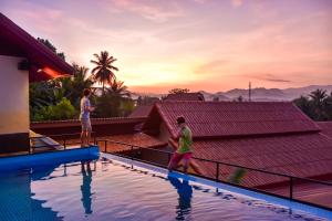 a group of people standing on the edge of a swimming pool at Mad Monkey Luang Prabang in Luang Prabang