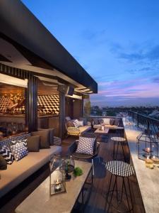 a rooftop patio with couches and tables on a building at ARTOTEL Thamrin Jakarta in Jakarta