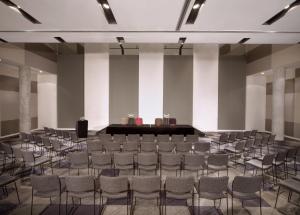 a room with chairs and a stage in the middle at ARTOTEL Thamrin Jakarta in Jakarta