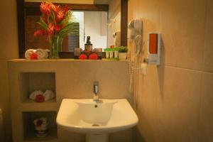 a bathroom with a white sink and a phone at Eco Boutique Hotel Vista Las Islas Reserva Natural in Paquera