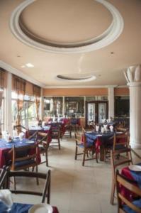 a dining room with tables and chairs in a restaurant at Niagara Hotel in Accra