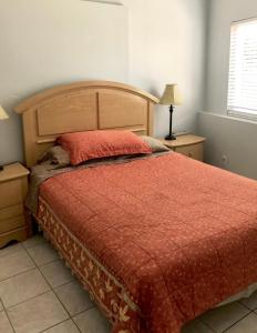 a bedroom with a bed with a red comforter at 3 Bedrooms Guest House, Pacific Beach, Sea World, Downtown,& 3 bus lines-3 in San Diego