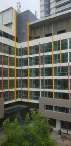 a large office building with yellow and red columns at Bizotel Premier Hotel & Residence in Bangkok