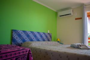 a bedroom with a bed and a green wall at Aparts Dunas de Valizas in Barra de Valizas