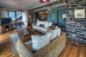 a living room with couches and a stone wall at Number 15 Ocean & City View Villas in Funchal