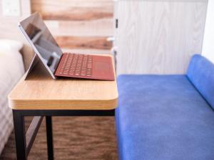 a laptop computer sitting on a table next to a couch at Super Hotel Premier Shimonoseki in Shimonoseki