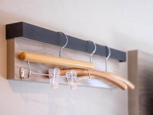 a wooden hanger with tongs and glasses on it at Super Hotel Premier Shimonoseki in Shimonoseki +64 photos