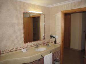 a bathroom with a sink and a mirror at Hotel Room in Pontevedra