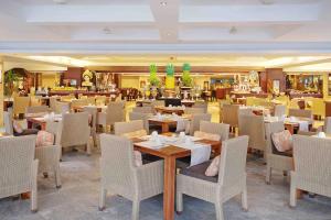 a dining room filled with tables and chairs at Discovery Kartika Plaza Hotel in Kuta