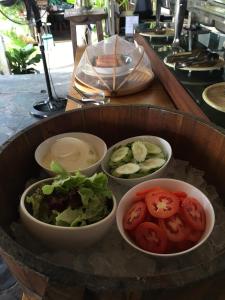 a bowl of food with bowls of vegetables on a table at Cookies Salad Resort in Salad Beach