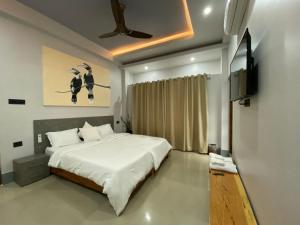 a bedroom with a bed and a flat screen tv at Magen in Imphal