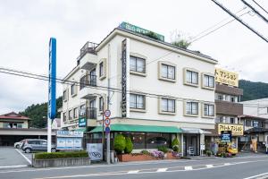 a large white building on the corner of a street at Kawaguchiko Station Inn in Fujikawaguchiko