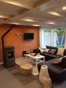a living room with a couch and a fireplace at Terrasses de Malmedy Chalet 113 in Malmedy