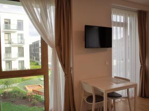 a room with a table and a window with a tv at Elzbietos centro apartamentai in Vilnius