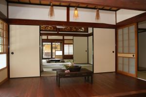 a living room with white doors and a table at せとうち古民家ステイズHiroshima 不老仙 in Shōbara