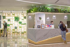 una tienda con gente de pie alrededor de un mostrador con plantas en Green Hotel - West District, en Taichung