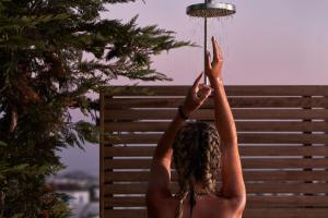 a woman with her arms in the air at 18 Grapes Hotel in Agios Prokopios