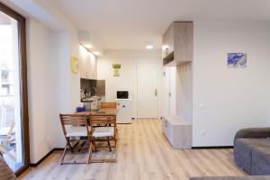a kitchen and a living room with a table and chairs at Snow Gudauri in Gudauri