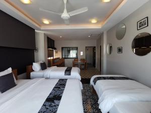 a hotel room with three beds and a dining room at The Besavana Phuket - SHA Extra Plus in Phuket Town
