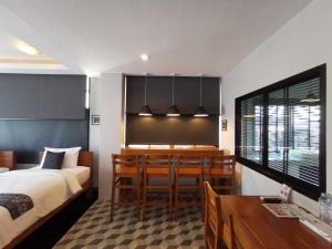 a bedroom with a bed and a dining room at The Besavana Phuket - SHA Extra Plus in Phuket Town