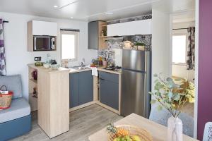 a kitchen with a stainless steel refrigerator and a table at Camping International in Calvi