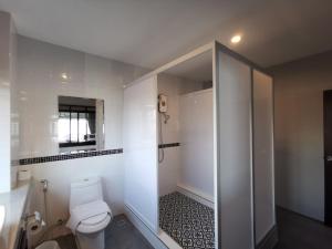 a white bathroom with a toilet and a shower at The Besavana Phuket - SHA Extra Plus in Phuket Town