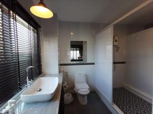 a white bathroom with a sink and a toilet at The Besavana Phuket - SHA Extra Plus in Phuket Town