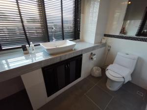 a bathroom with a white sink and a toilet at The Besavana Phuket - SHA Extra Plus in Phuket Town