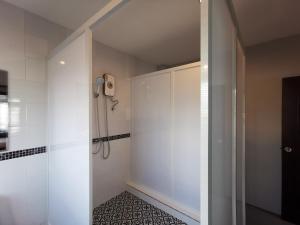 a bathroom with a shower with a phone on the wall at The Besavana Phuket - SHA Extra Plus in Phuket Town