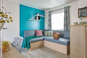 Camping International في كالفي: غرفة معيشة زرقاء مع أريكة وطاولة