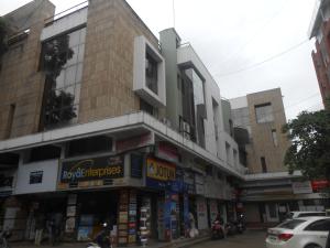 a street corner with a building with many shops at Hotel Pooja International in Nashik