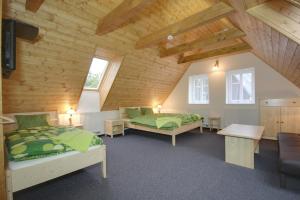 a bedroom with two beds and a wooden ceiling at Pension Roubenka in Harrachov