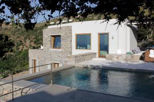 una casa con piscina frente a una casa en Villa Orso Blue I, en Ioulida