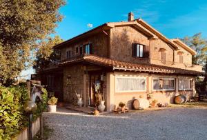 een groot bakstenen huis met een oprit bij Maremma Nel Tufo in Pitigliano