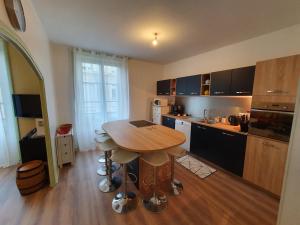a kitchen with a wooden table and a wooden floor at La tanière du Corsaire -16 Pers in Redon