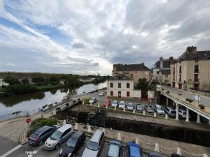 a bunch of cars parked in a parking lot next to a river at La tanière du Corsaire -16 Pers in Redon