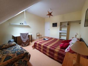 a bedroom with a bed and a desk in it at La tanière du Corsaire -16 Pers in Redon