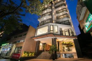 a tall white building with stairs in front of it at The Bloom Hanoi - Bespoke Living in Hanoi